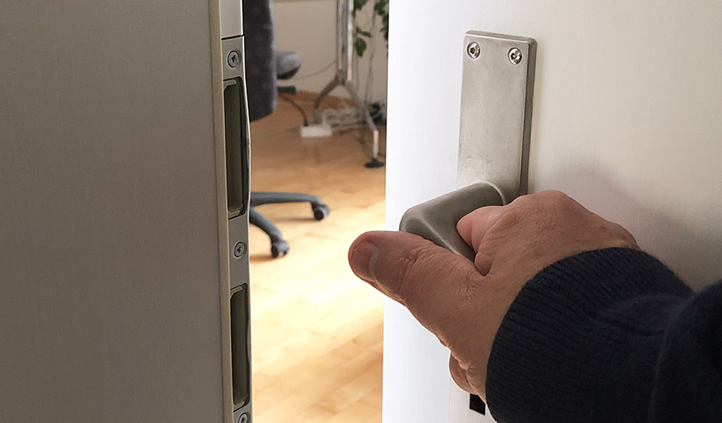Hand öffnet eine Türe